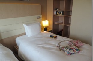 a bed with a white sheet and a purse on it