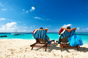 two people sitting in chairs on a beach