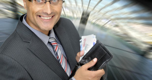 a man holding a wallet full of money