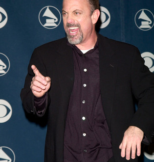 a man in a black suit pointing at something