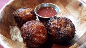 a group of meatballs with sauce on a wooden surface