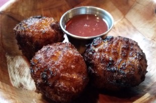 a group of meatballs with sauce on a wooden surface