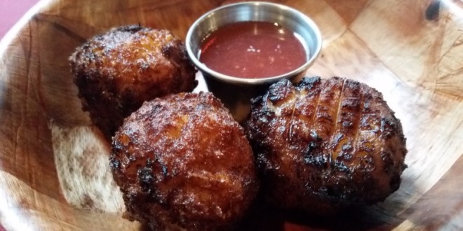 a group of meatballs with sauce on a wooden surface