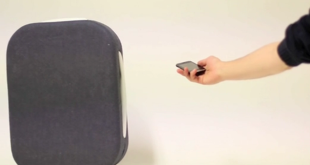 a hand holding a phone next to a suitcase