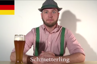 a man in a hat and suspenders sitting at a table with a glass of beer