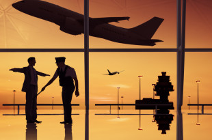 a silhouette of two men in an airport