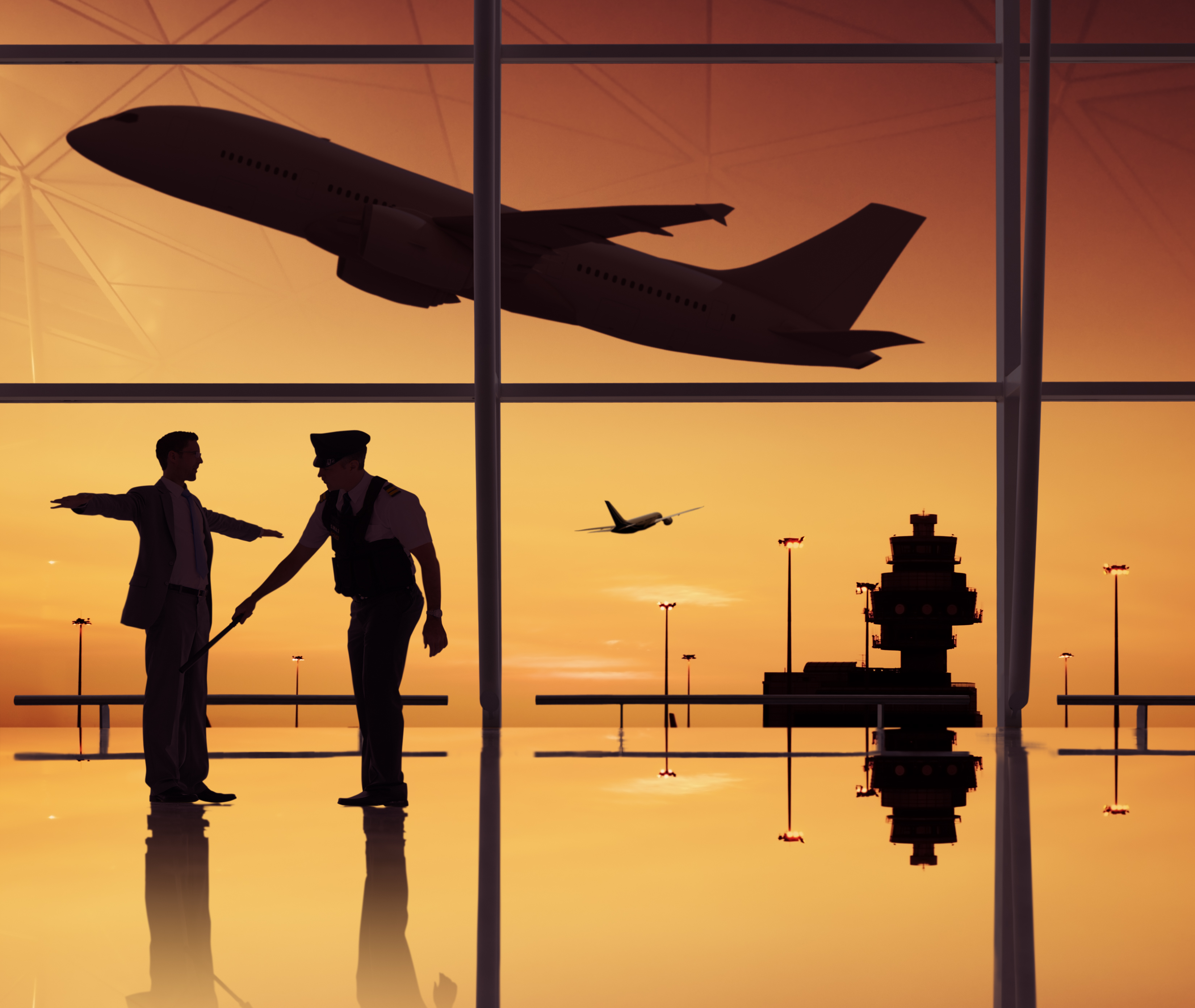 a silhouette of two men in an airport