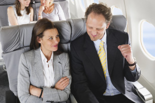 a man and woman sitting in an airplane