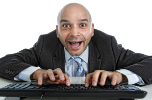 a man in a suit and tie typing on a keyboard