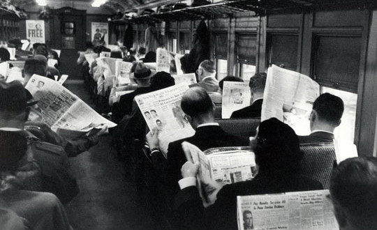 a group of people on a train reading newspapers