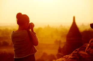 a woman taking a picture of a landscape