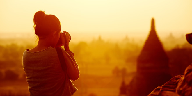 a woman taking a picture of a landscape