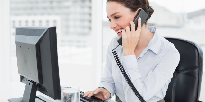 a woman on the phone and looking at a computer