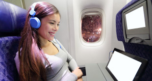 a woman wearing headphones and sitting in an airplane