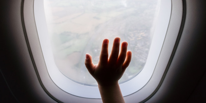 a child's hand reaching out of an airplane window