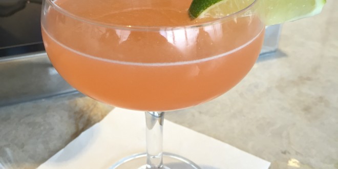a glass with a drink and a lime wedge