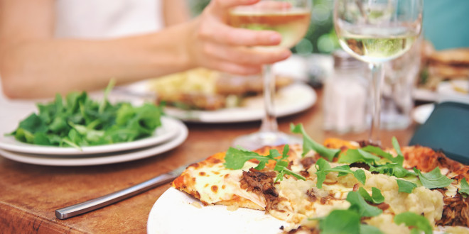 a plate of pizza and wine glasses