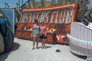 two women standing in front of a sign