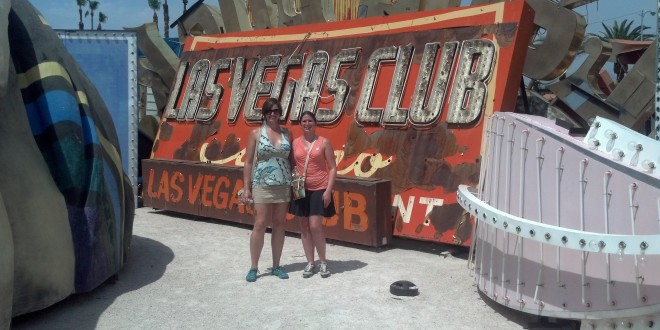 two women standing in front of a sign