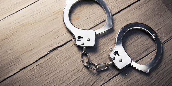 a pair of handcuffs on a wood surface