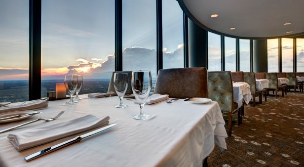 a table with wine glasses and a view of the city