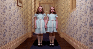 two girls in dresses holding hands in a hallway