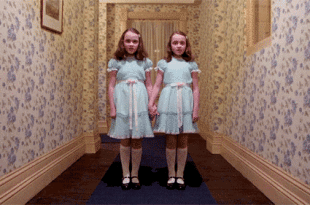 two girls in dresses holding hands in a hallway