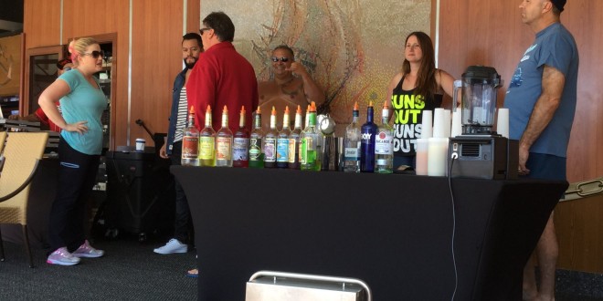 a group of people standing around a table with drinks