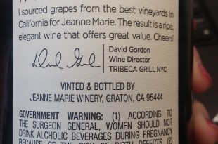 a hand holding a bottle of wine
