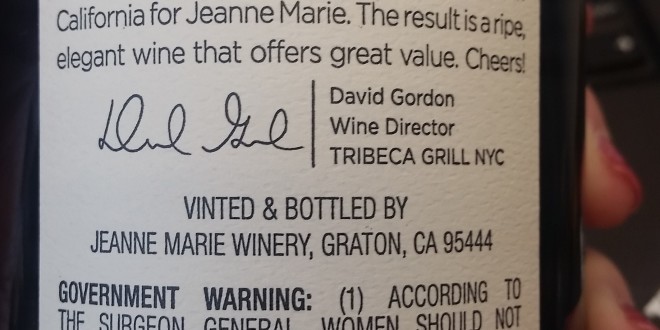 a hand holding a bottle of wine
