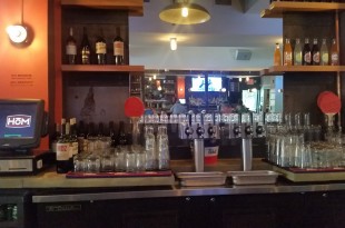 a bar with many bottles and glasses