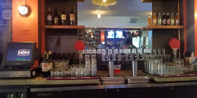 a bar with many bottles and glasses