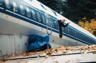 a man waving from a window of an airplane