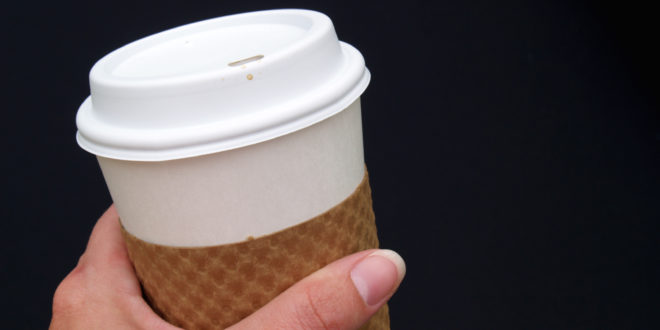 a hand holding a coffee cup
