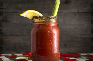 a glass jar with a drink and a lemon on top