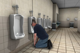 a man kneeling on the floor in a bathroom with urinals