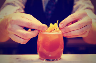 a person's hands making a drink