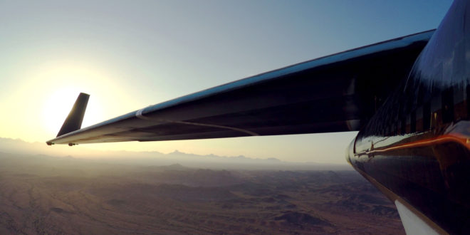 an wing of an airplane over a desert
