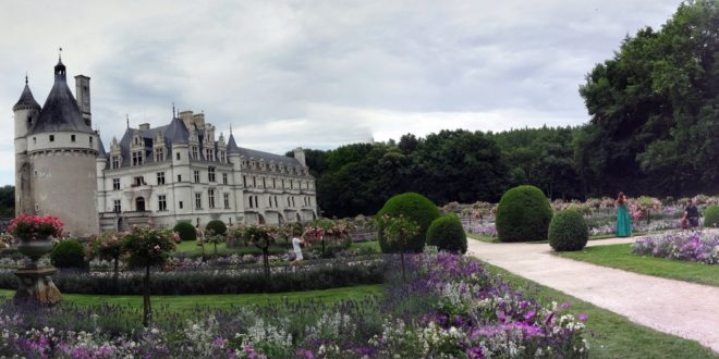 a large white building with a garden and trees with Cawdor Castle in the background