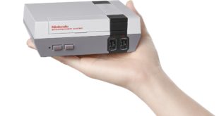 a hand holding a video game console