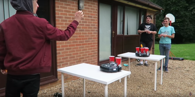 a man taking a selfie with a table with cups on it