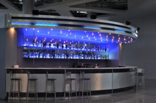 a bar with a row of bottles on the shelves