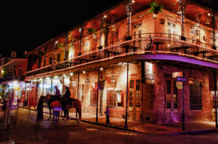 a building with a balcony and a couple of horses