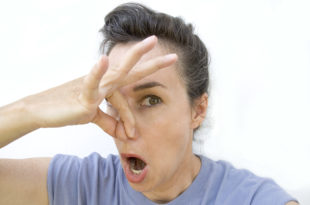 a woman holding her nose with her hand