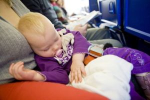 a baby sleeping on a plane