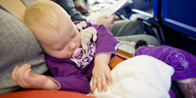 a baby sleeping on a plane
