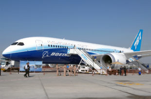 a group of people standing next to a plane