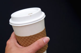 a hand holding a coffee cup