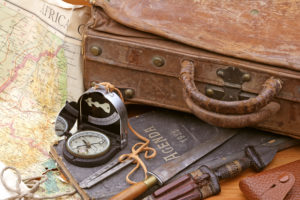 a compass and a suitcase with a map and knife