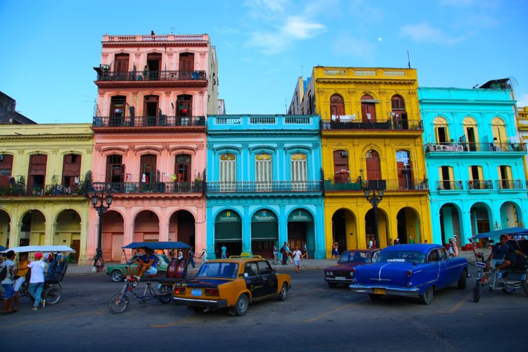 a colorful buildings with cars and people in the background
